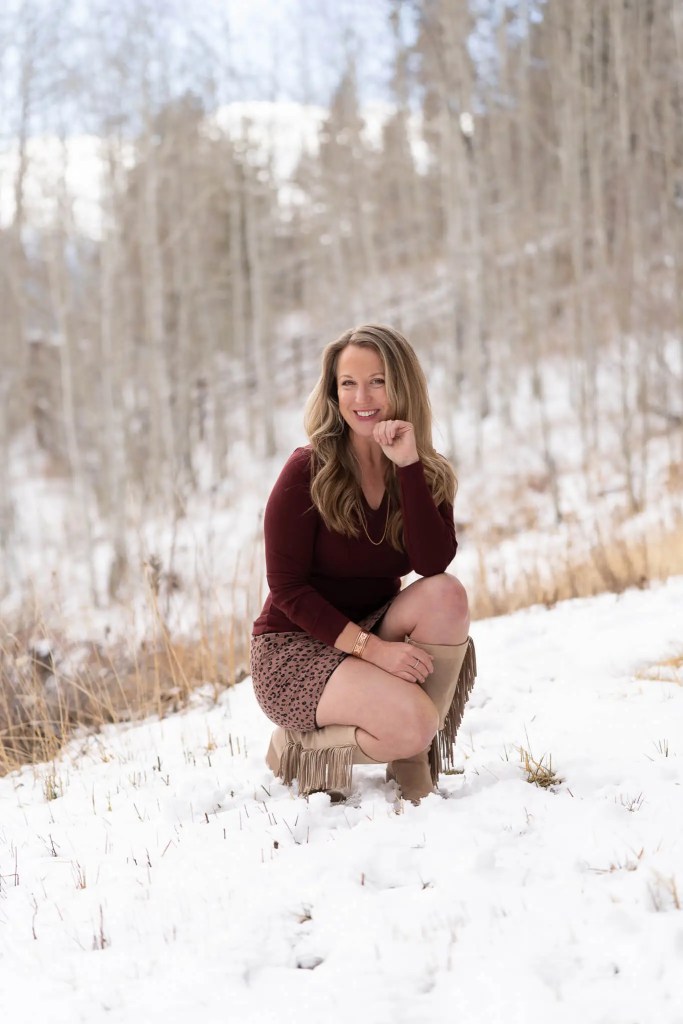 Emily Wishall smiling in a peaceful winter landscape, reflecting her connection to nature and whole-body well-being.